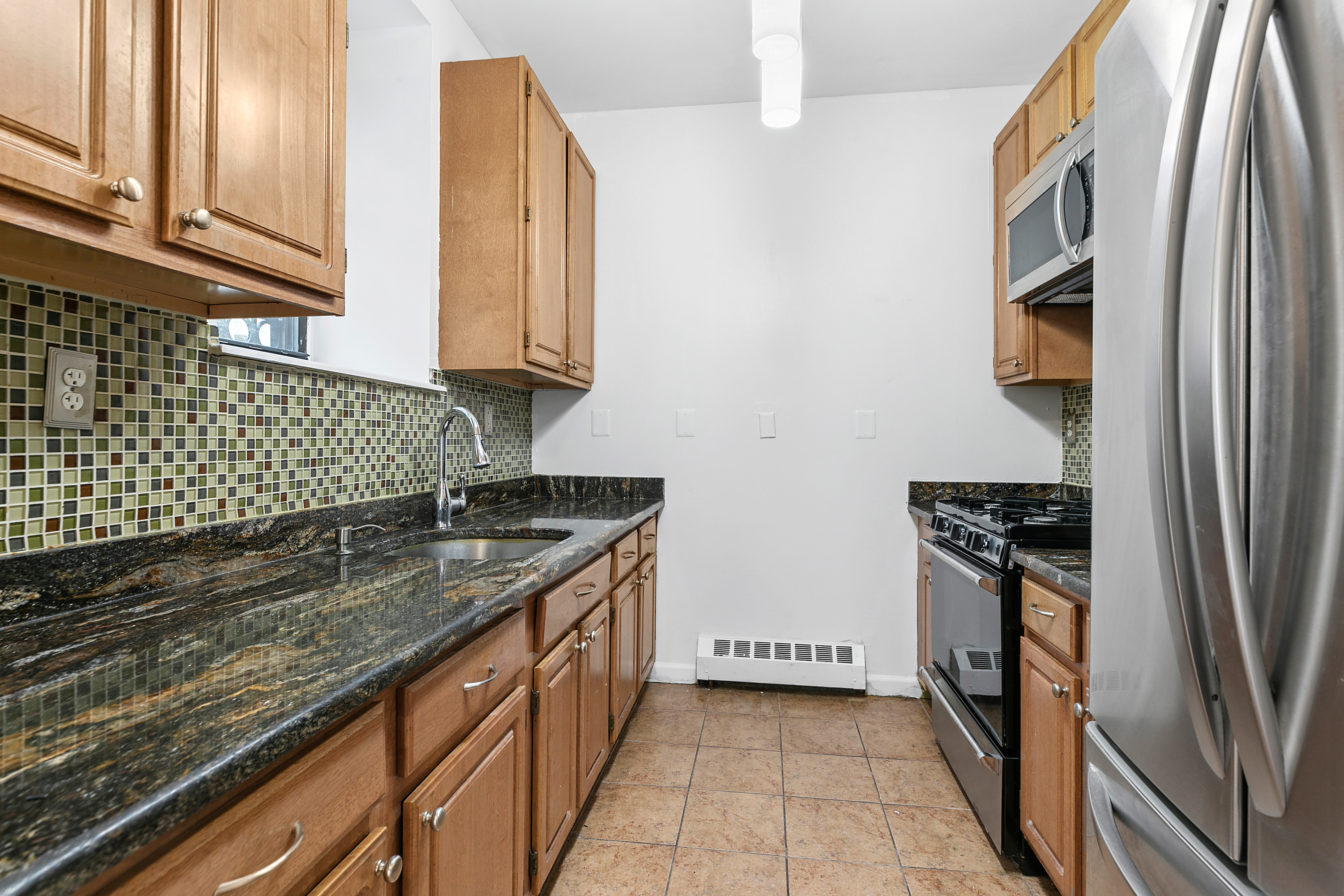 418 West 129th Street, Unit 4 Manhattan, NY 10027 - Photo 5 of 15 a kitchen with stainless steel appliances granite countertop a refrigerator and a stove