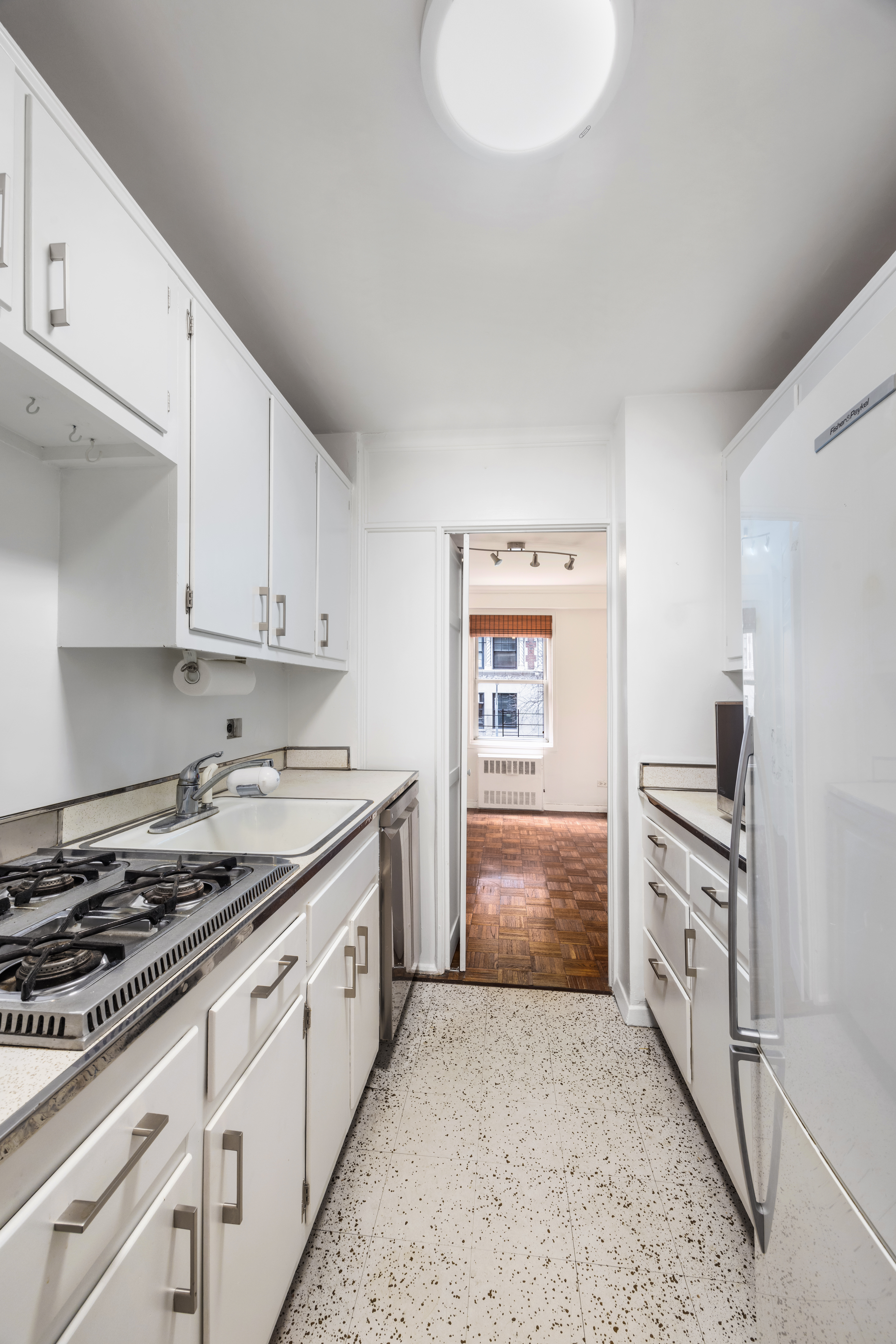 1199 Park Avenue, Unit 3G Manhattan, NY 10128 - Photo 9 of 12 a kitchen with granite countertop white cabinets and appliances