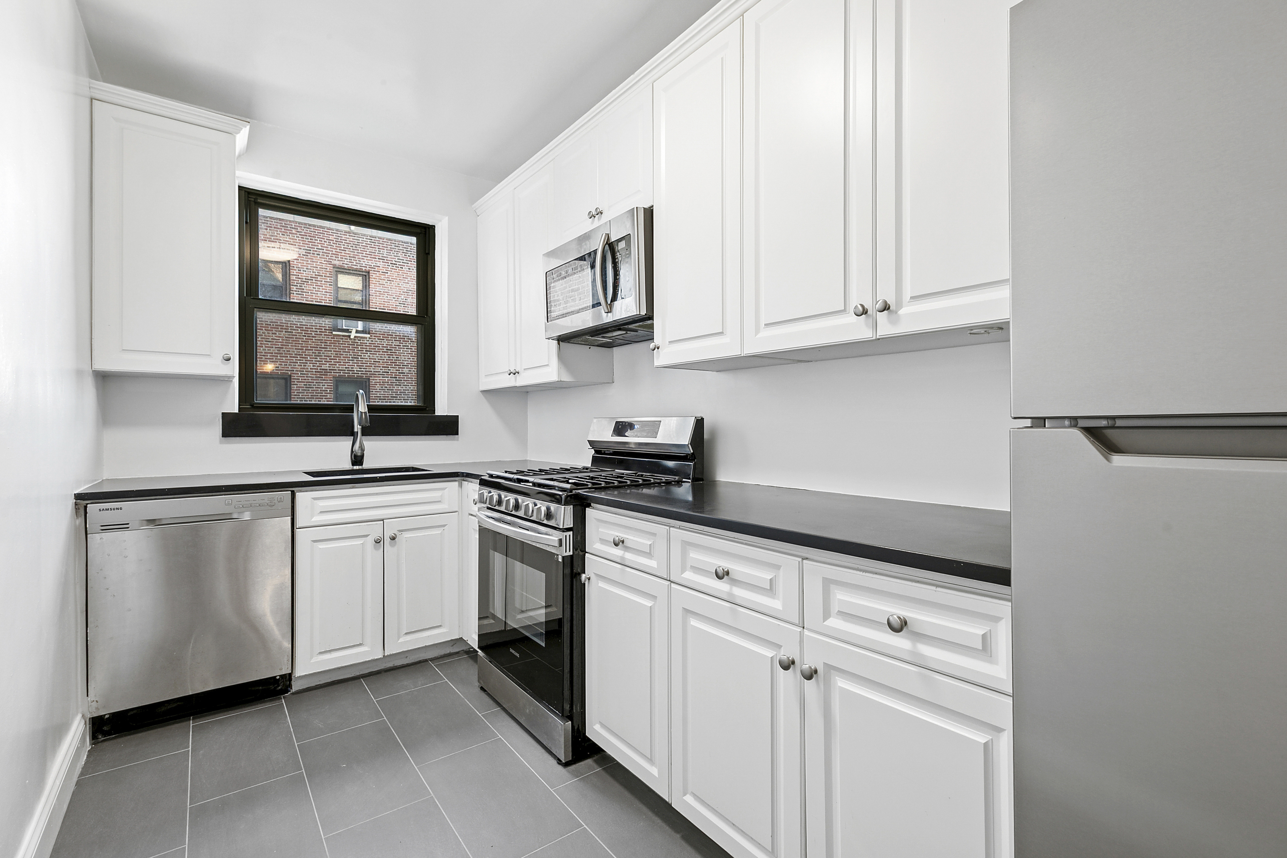 159-00 Riverside Drive West, Unit 4L70 Manhattan, NY 10032 - Photo 4 of 18 a kitchen with white cabinets and a sink
