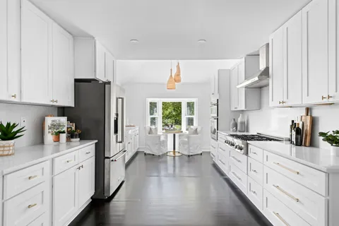 a kitchen with white cabinets and appliances