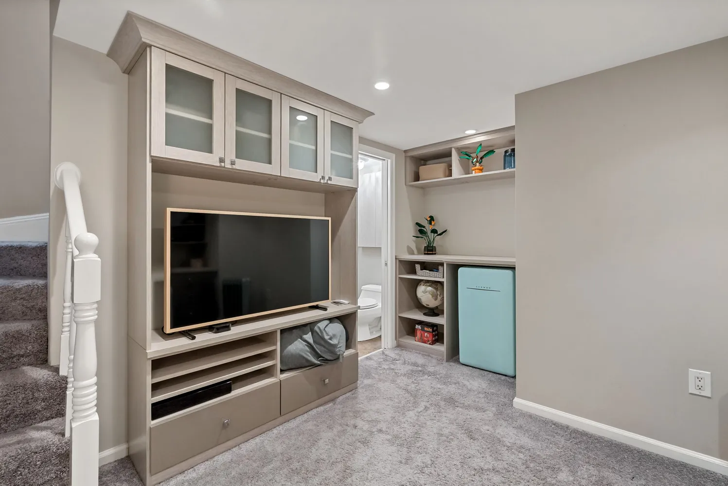 a living room with stainless steel appliances white walls and a fireplace