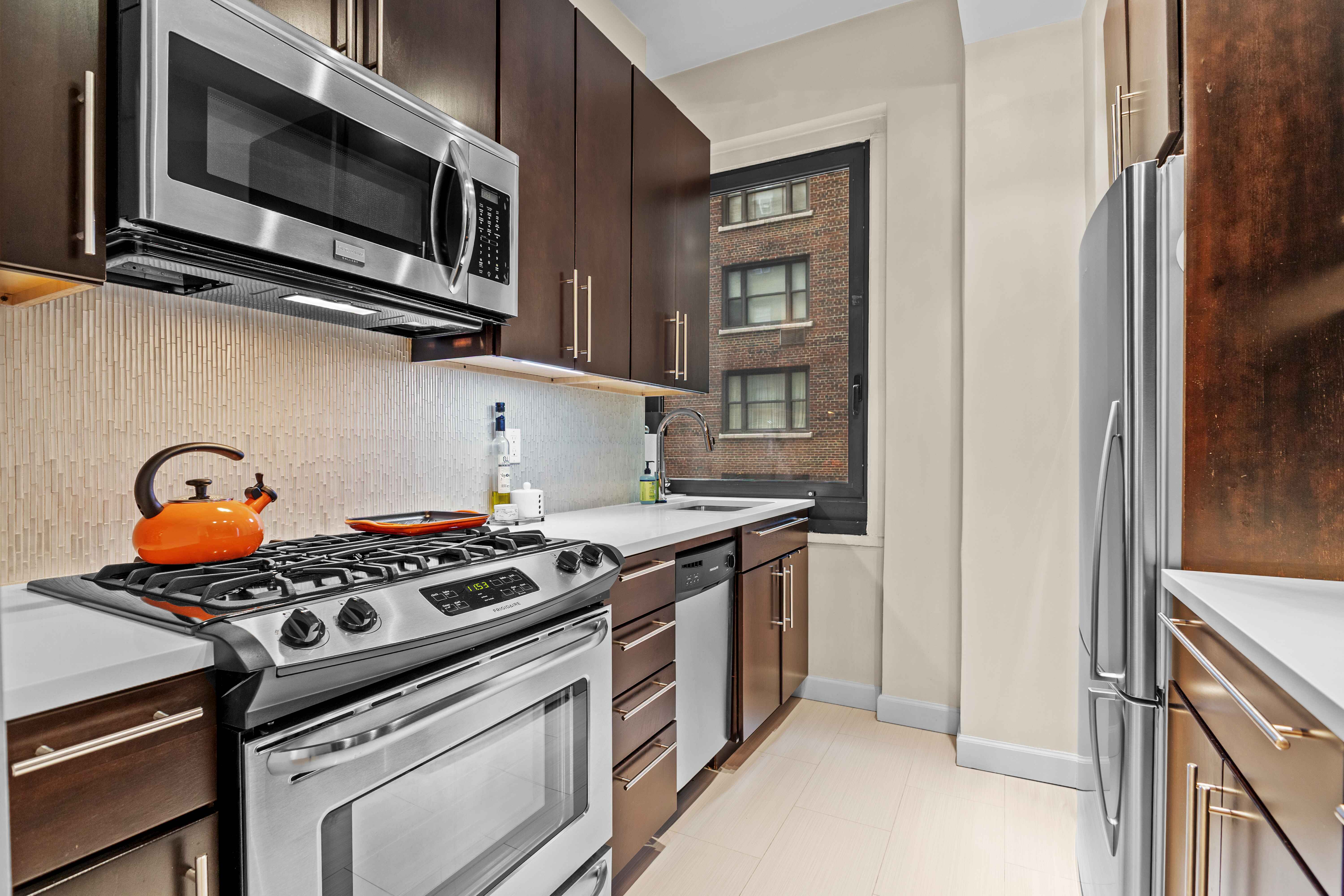 263 West End Avenue, Unit 6E Manhattan, NY 10023 - Photo 5 of 12 a kitchen with stainless steel appliances a stove and a microwave