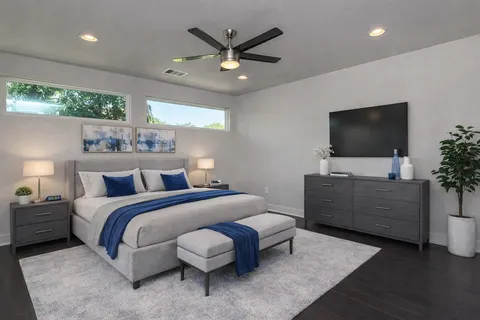 a bedroom with bed tv and window