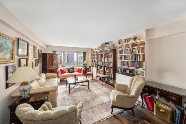 a living room with furniture and a book shelf