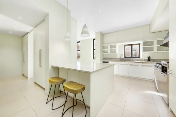 a large white kitchen with a sink and cabinets