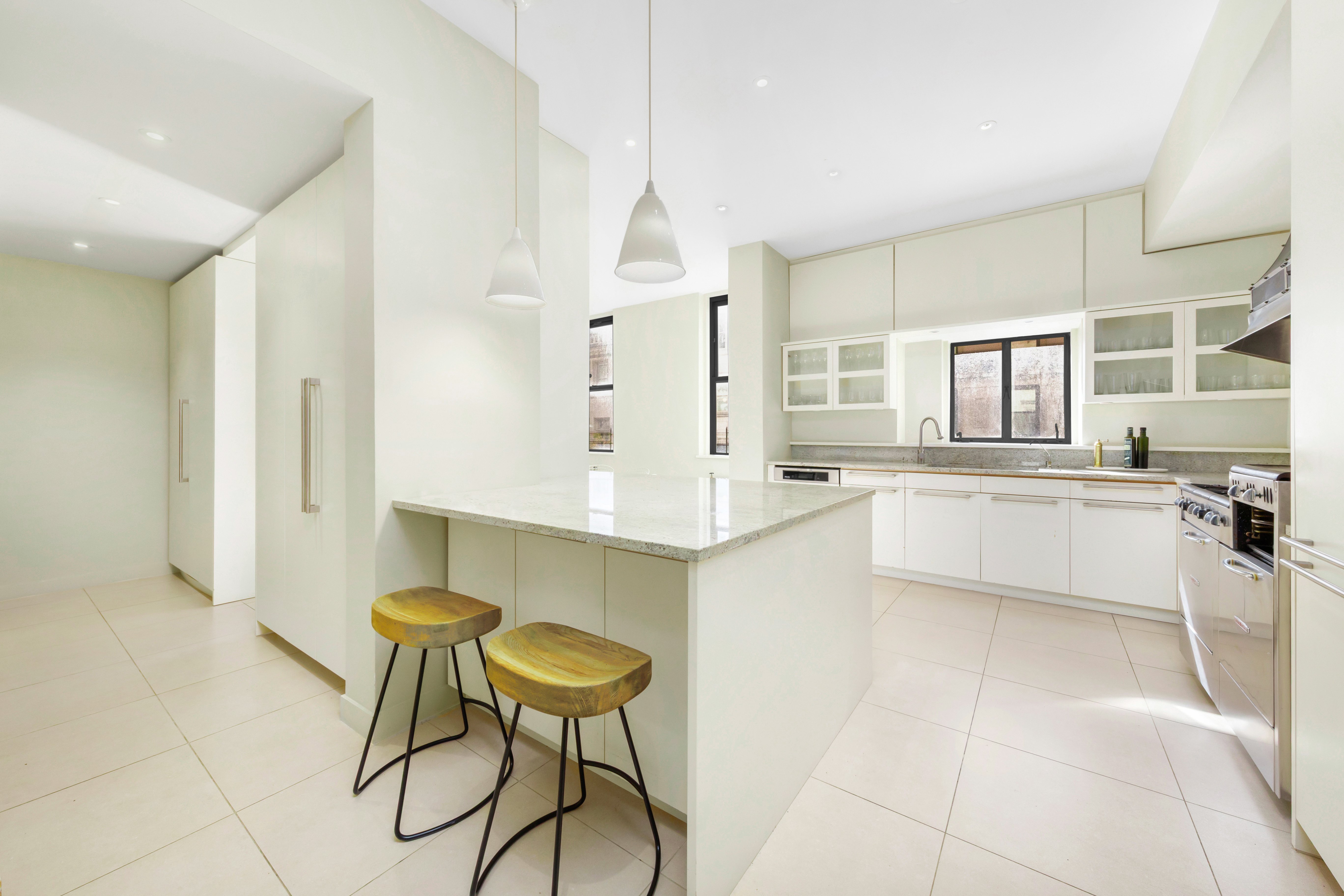 990 5th Avenue, Unit 4/5 Manhattan, NY 10075 - Photo 7 of 18 a large white kitchen with a sink and cabinets