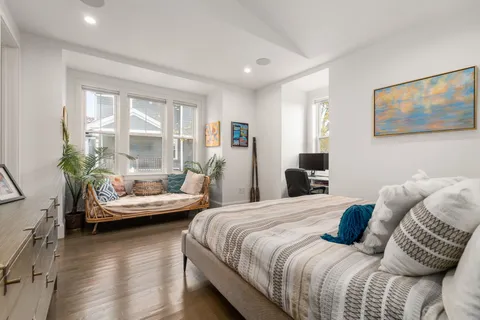 a bedroom with a bed and wooden floor