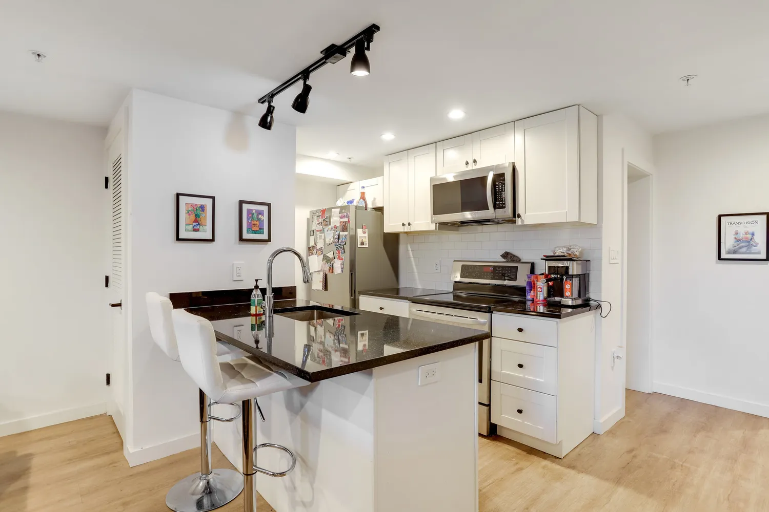 a kitchen with stainless steel appliances granite countertop a sink and a refrigerator