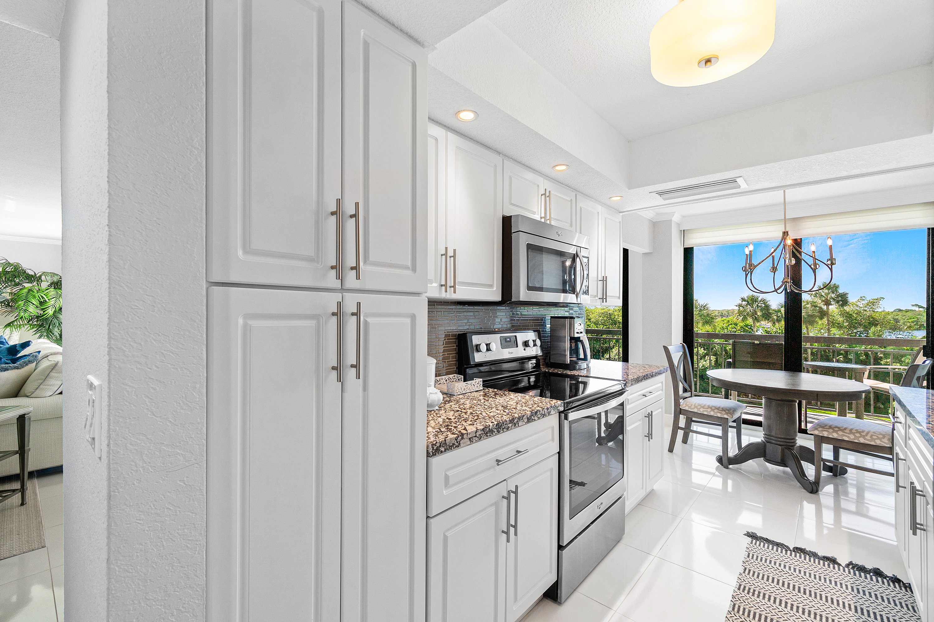 2003 North Ocean Boulevard, Unit 305 Boca Raton, FL 33431 - Photo 32 of 56 a kitchen with white cabinets and appliances