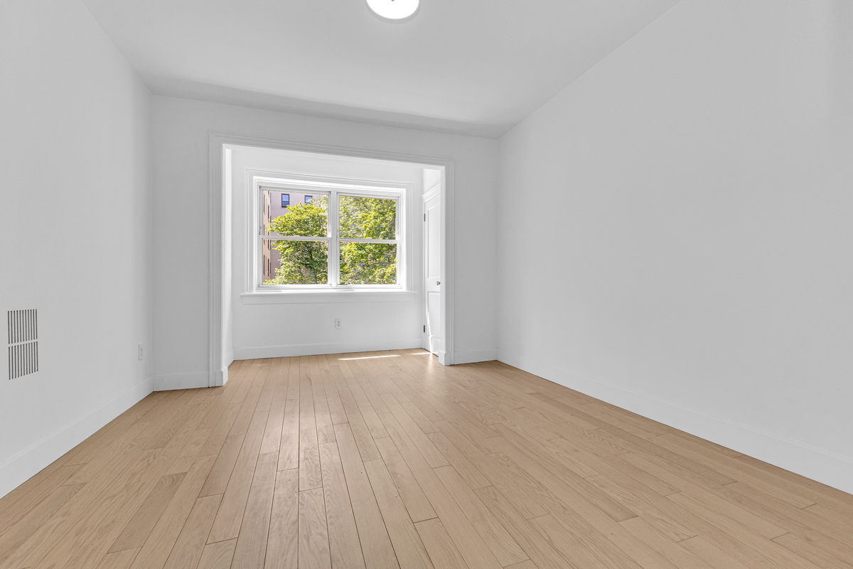 1050 Sterling Place Brooklyn, NY 11213 - Photo 18 of 23 an empty room with wooden floor and windows