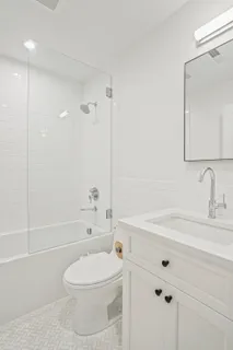 a bathroom with a sink a toilet and shower