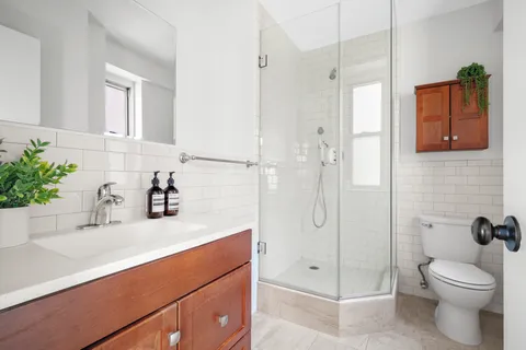 a bathroom with a sink a toilet and shower