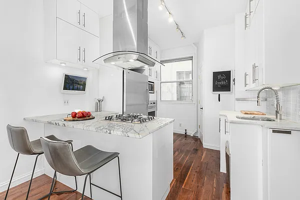 13 Downing Street, Unit 8 Manhattan, NY 10014 - Photo 5 of 10 a view of a kitchen with kitchen island a stove a sink and a refrigerator