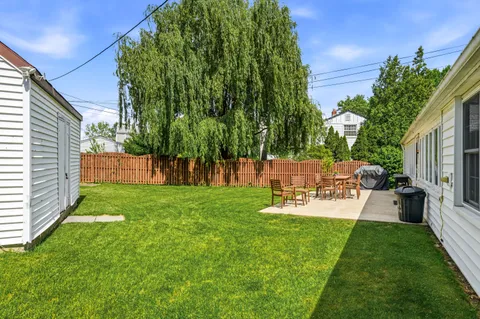a view of a chair and table in backyard of the house