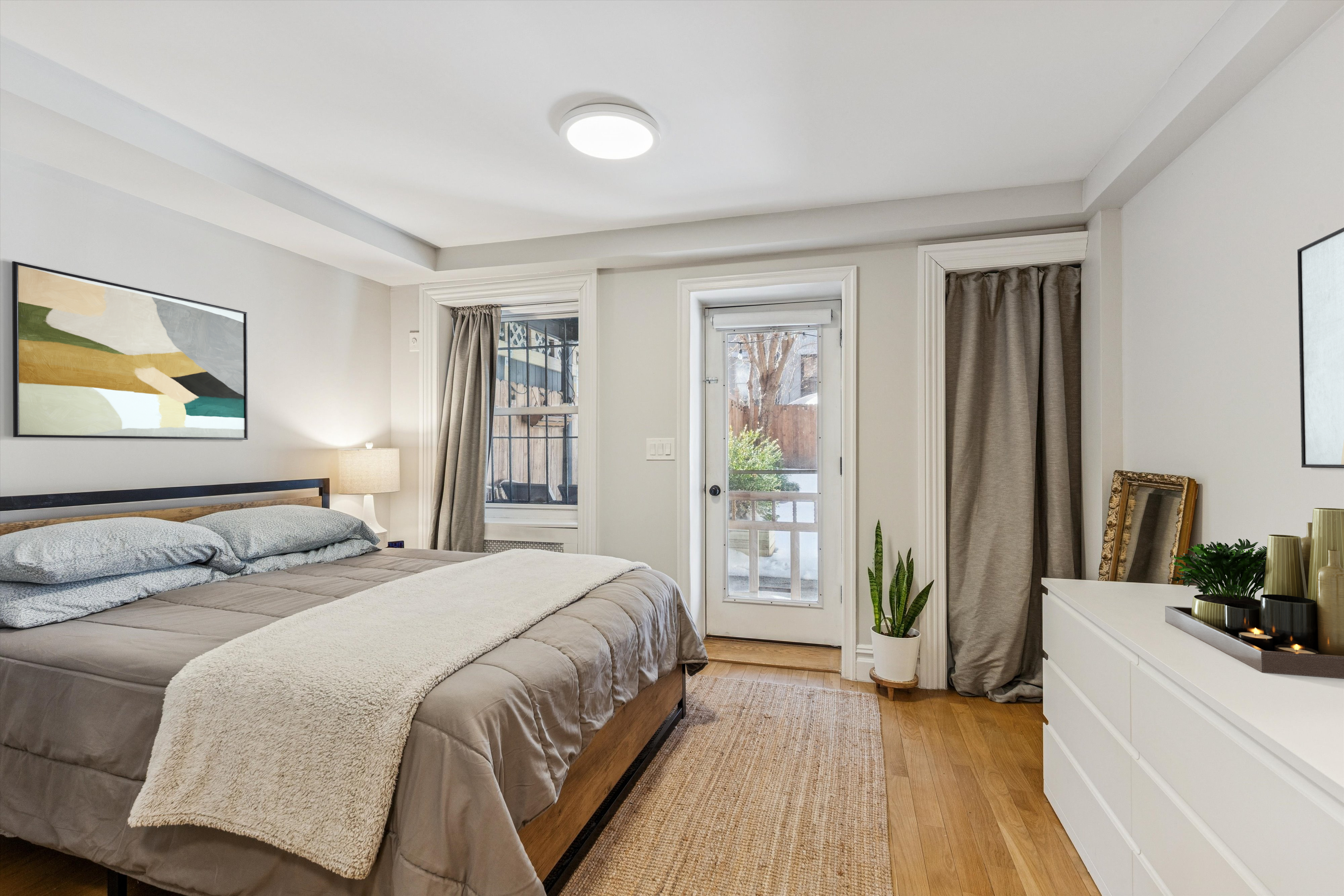 318 West 140th Street, Unit GARDEN Manhattan, NY 10030 - Photo 5 of 12 a bedroom with a bed and a flat screen tv