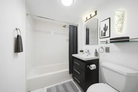 a bathroom with a granite countertop sink mirror toilet and bathtub