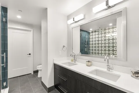 a bathroom with a double vanity sink mirror and toilet