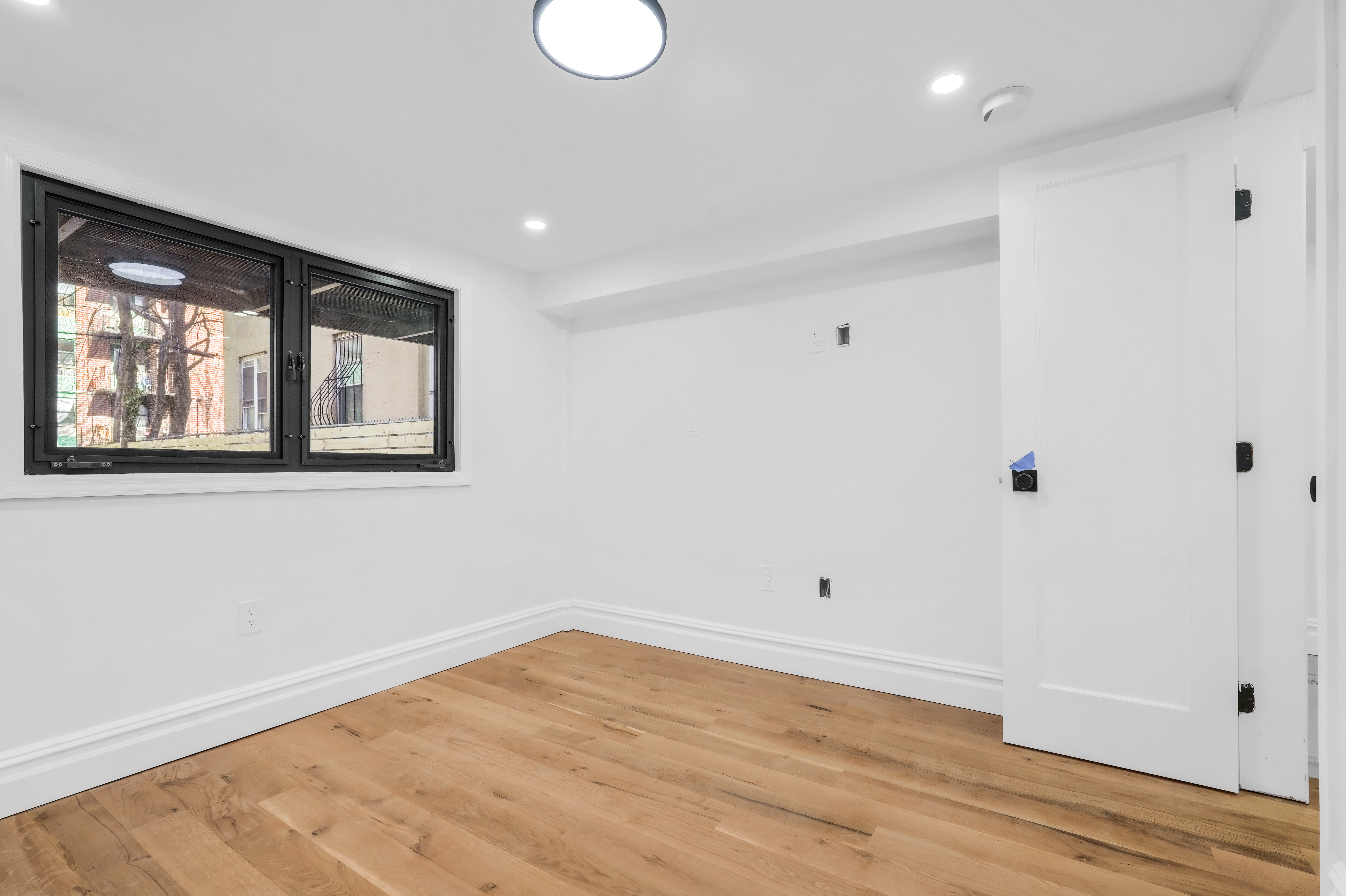 473 Monroe Street Brooklyn, NY 11221 - Photo 34 of 40 a view of empty room with wooden floor and fan