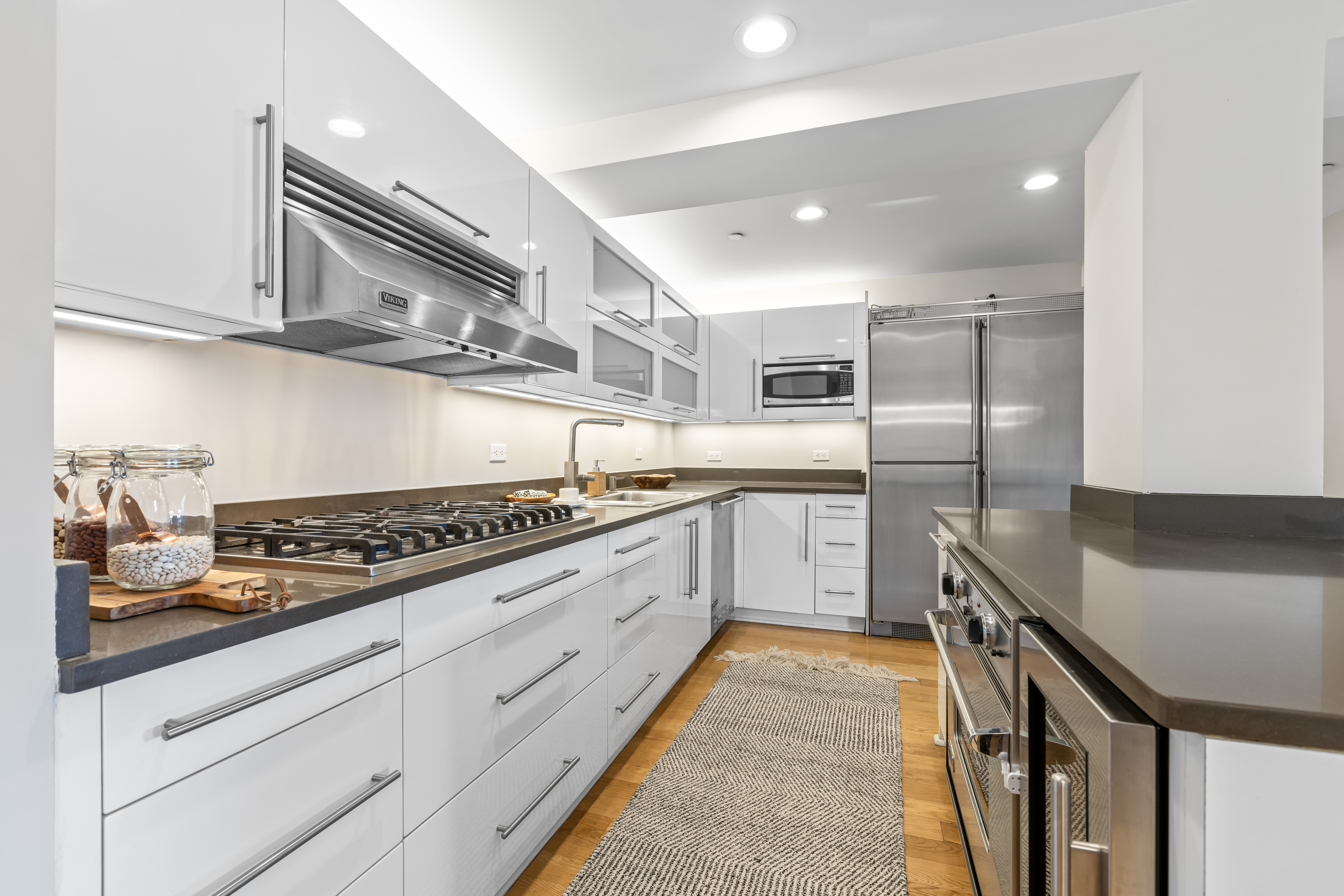 257 West 117th Street, Unit 6A Manhattan, NY 10026 - Photo 6 of 16 a large kitchen with stainless steel appliances granite countertop a stove a sink and a refrigerator