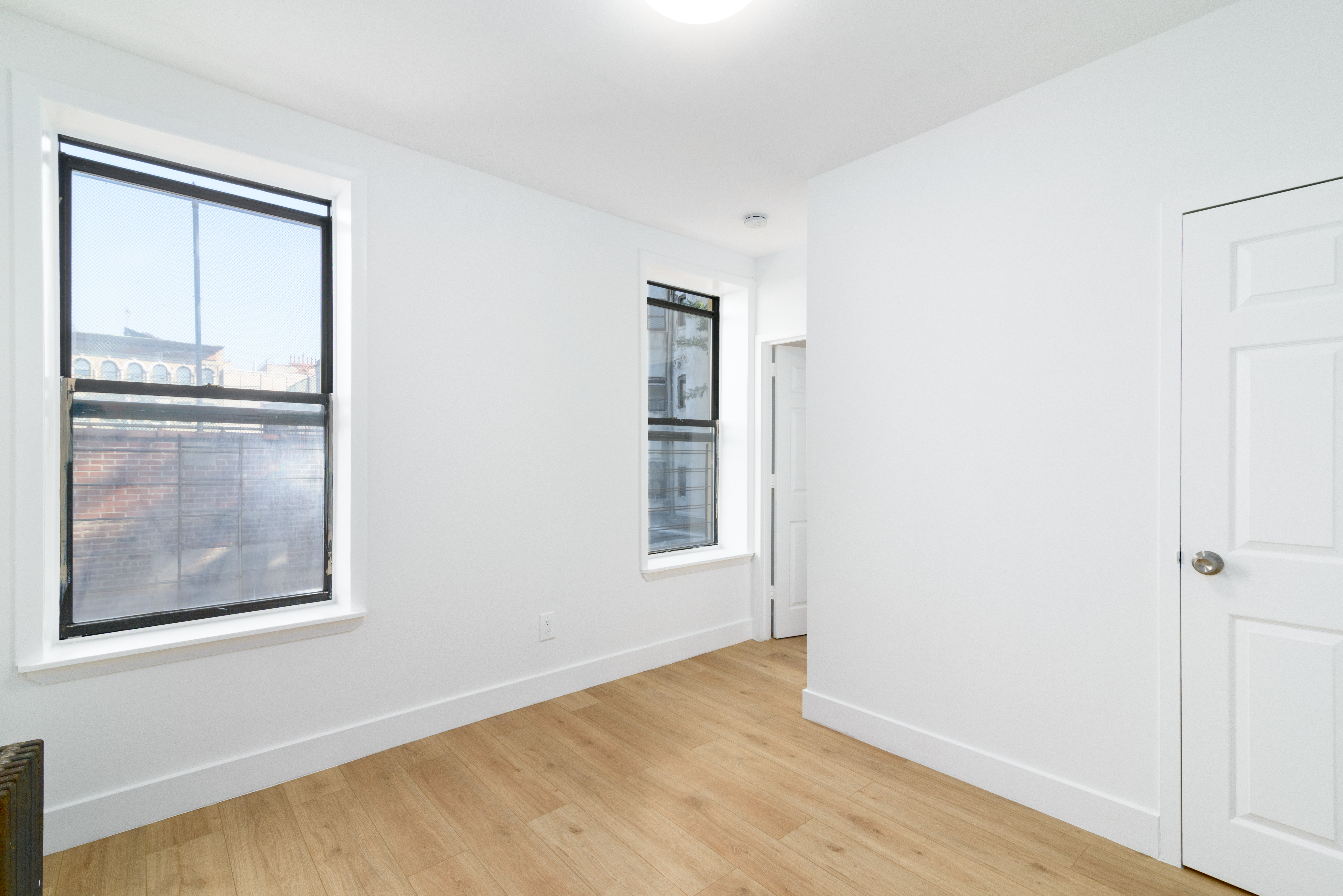 517 West 144th Street, Unit 9 Manhattan, NY 10031 - Photo 2 of 22 a view of an empty room with wooden floor and a window