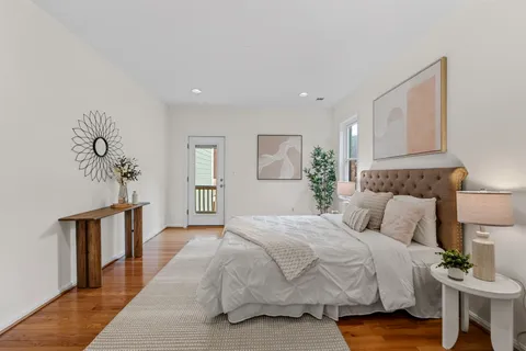 a living room with furniture potted plant and open kitchen view