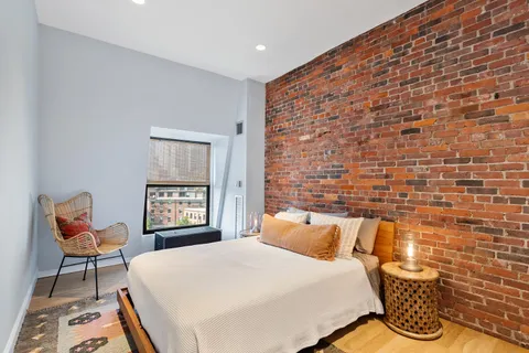 a spacious bedroom with a bed and a chair