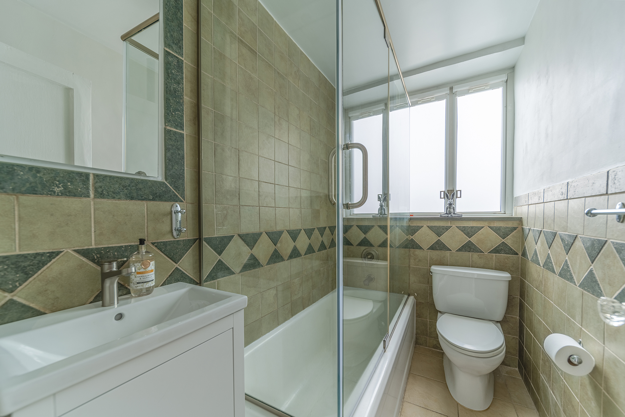 200 West 20th Street, Unit 1208 Manhattan, NY 10011 - Photo 12 of 14 a bathroom with a sink a toilet and shower