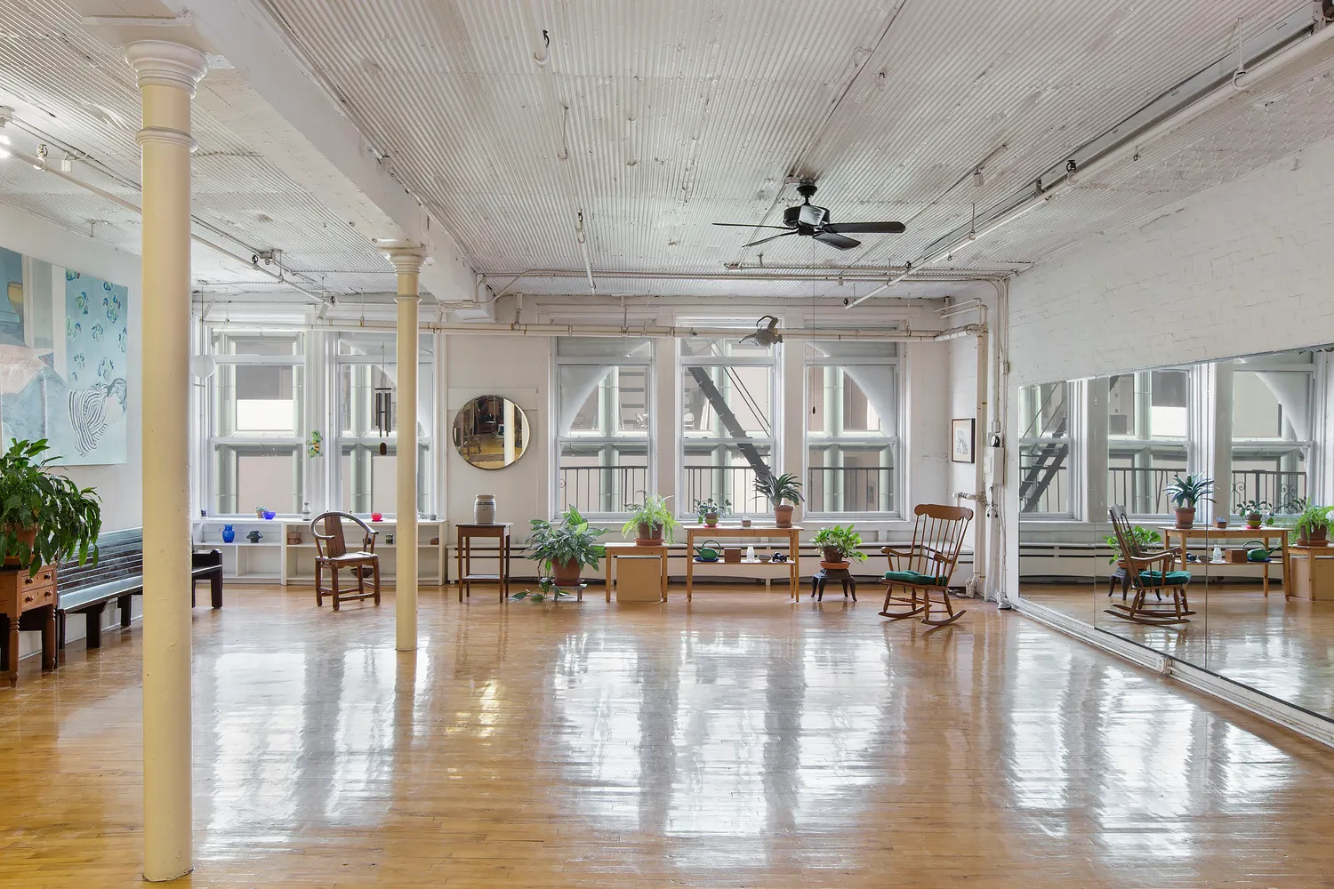 a living room filled with lots of furniture hardwood floor and a large window