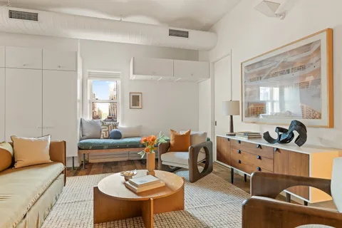 a living room with furniture a rug and a mirror