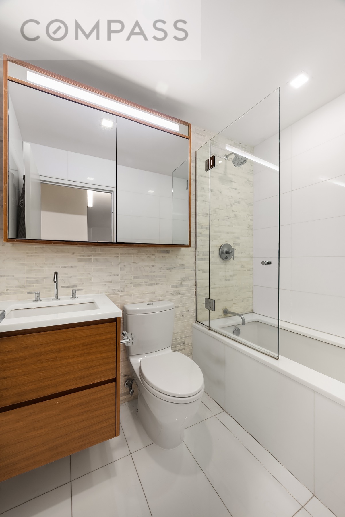 301 West 53rd Street, Unit 7H Manhattan, NY 10019 - Photo 5 of 11 a bathroom with a toilet a sink and shower