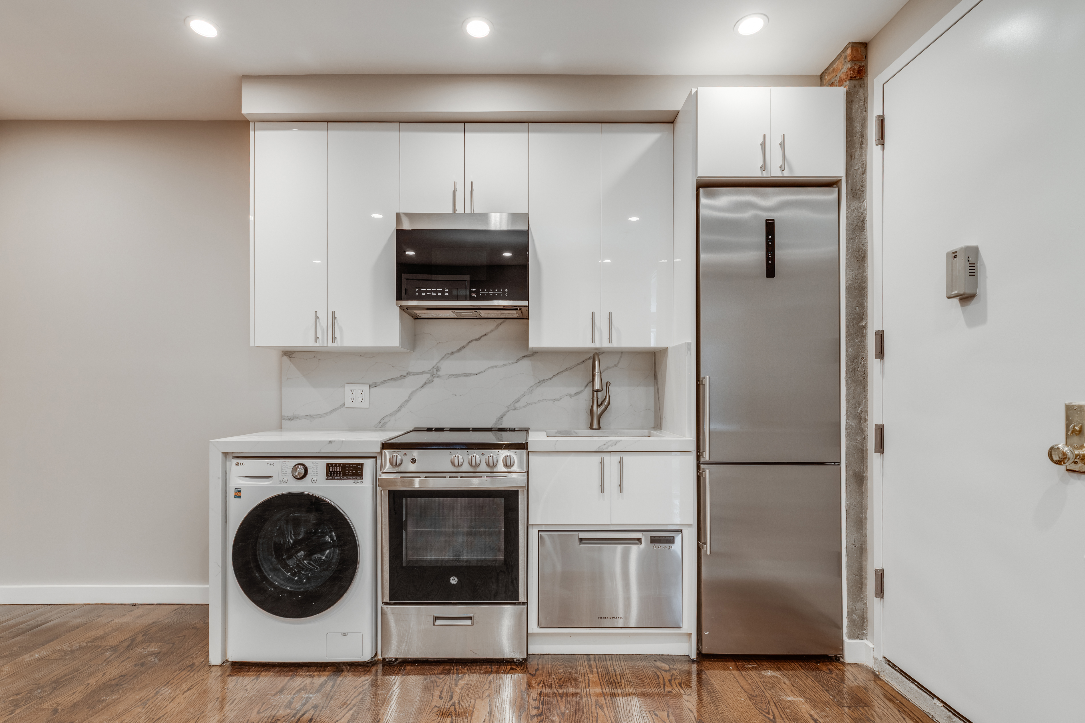 464 West 23rd Street, Unit 1R Manhattan, NY 10011 - Photo 4 of 9 a kitchen with stainless steel appliances a refrigerator a stove and white cabinets