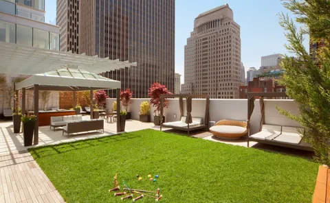 a swimming pool with outdoor seating and yard in the back