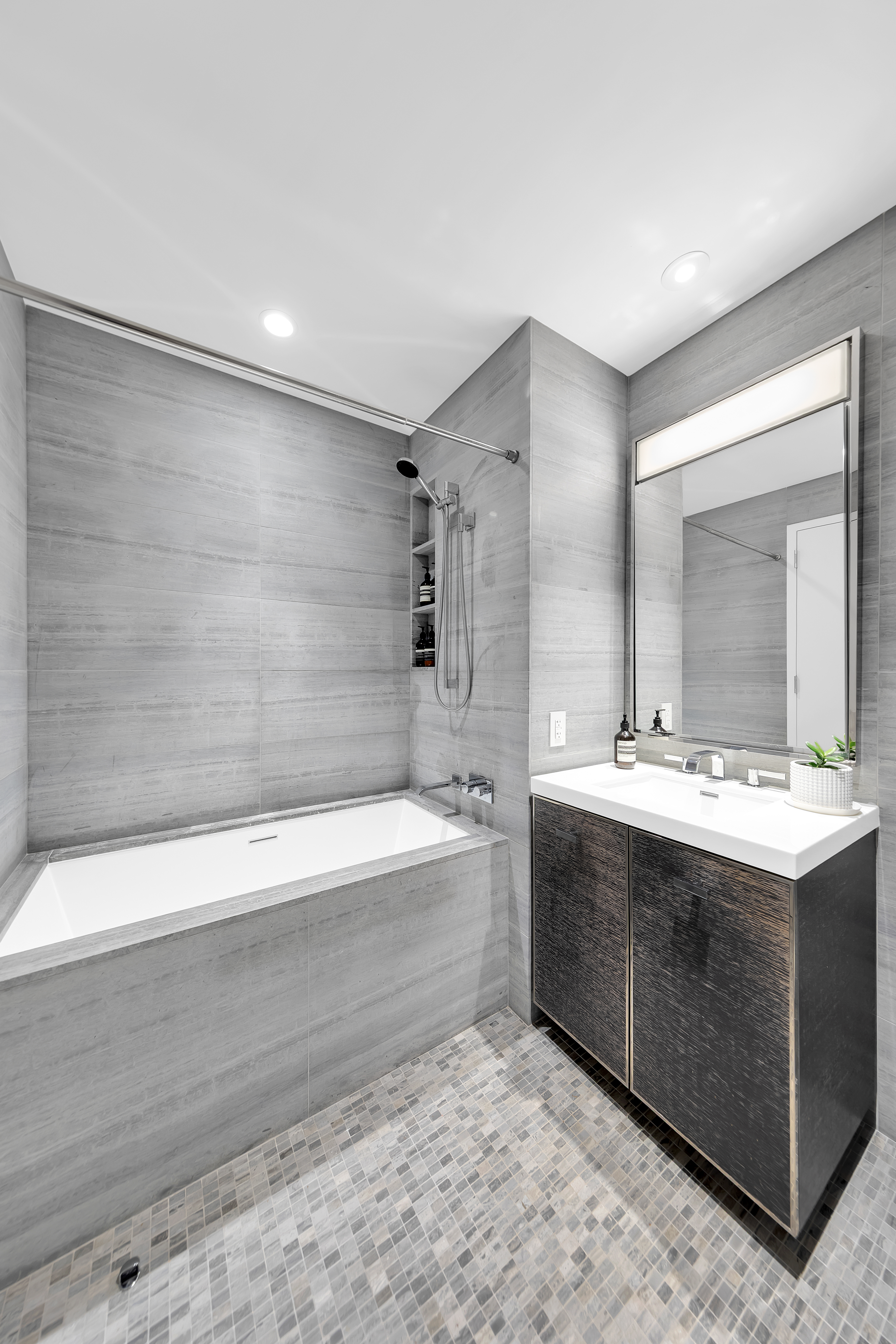 252 South Street, Unit 64G Manhattan, NY 10002 - Photo 7 of 24 a bathroom with a tub sink and mirror