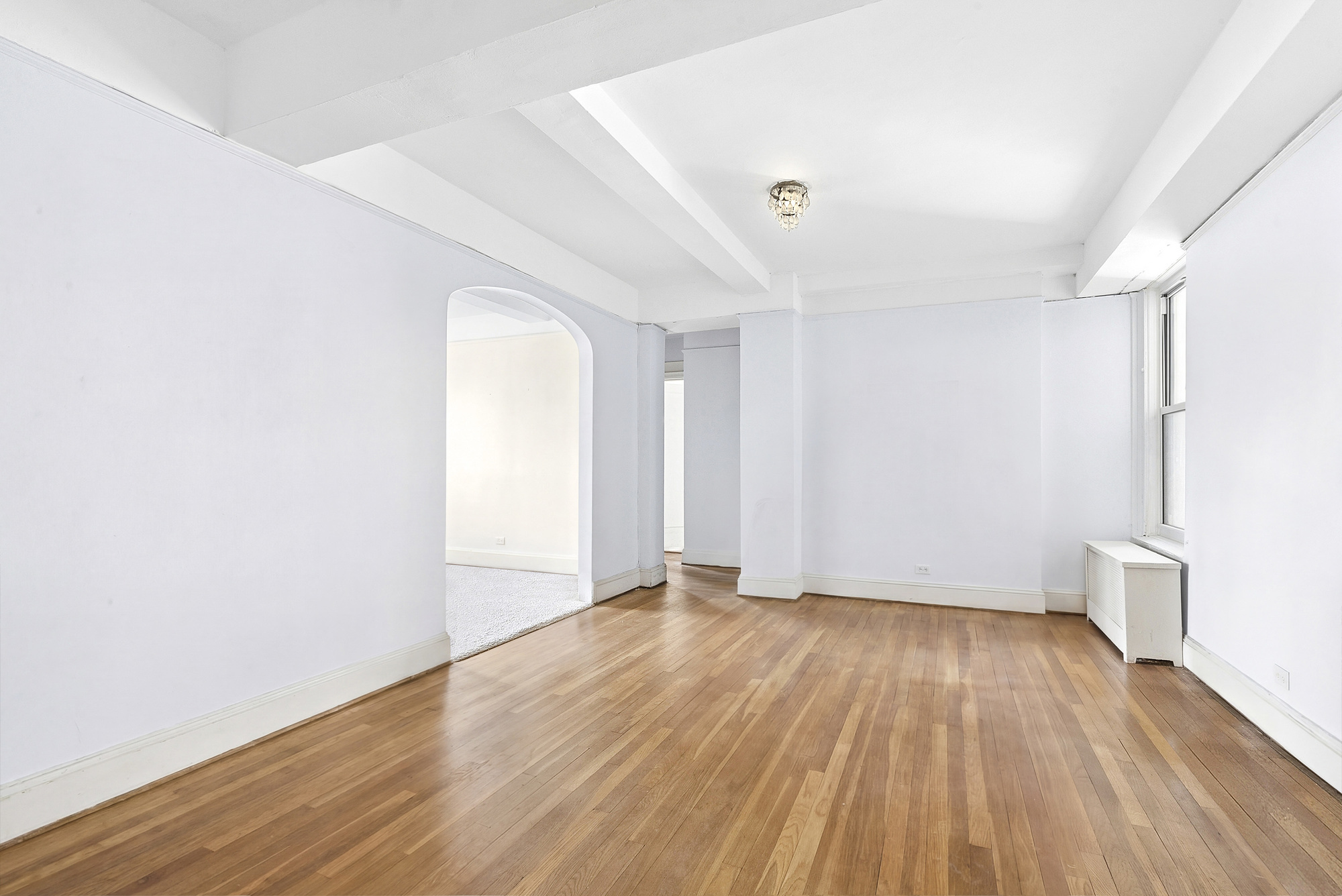 12 West 96th Street, Unit 9A Manhattan, NY 10025 - Photo 2 of 14 an empty room with wooden floor and windows