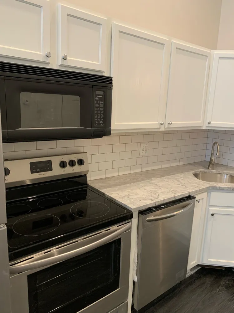 a kitchen with granite countertop a stove microwave and sink