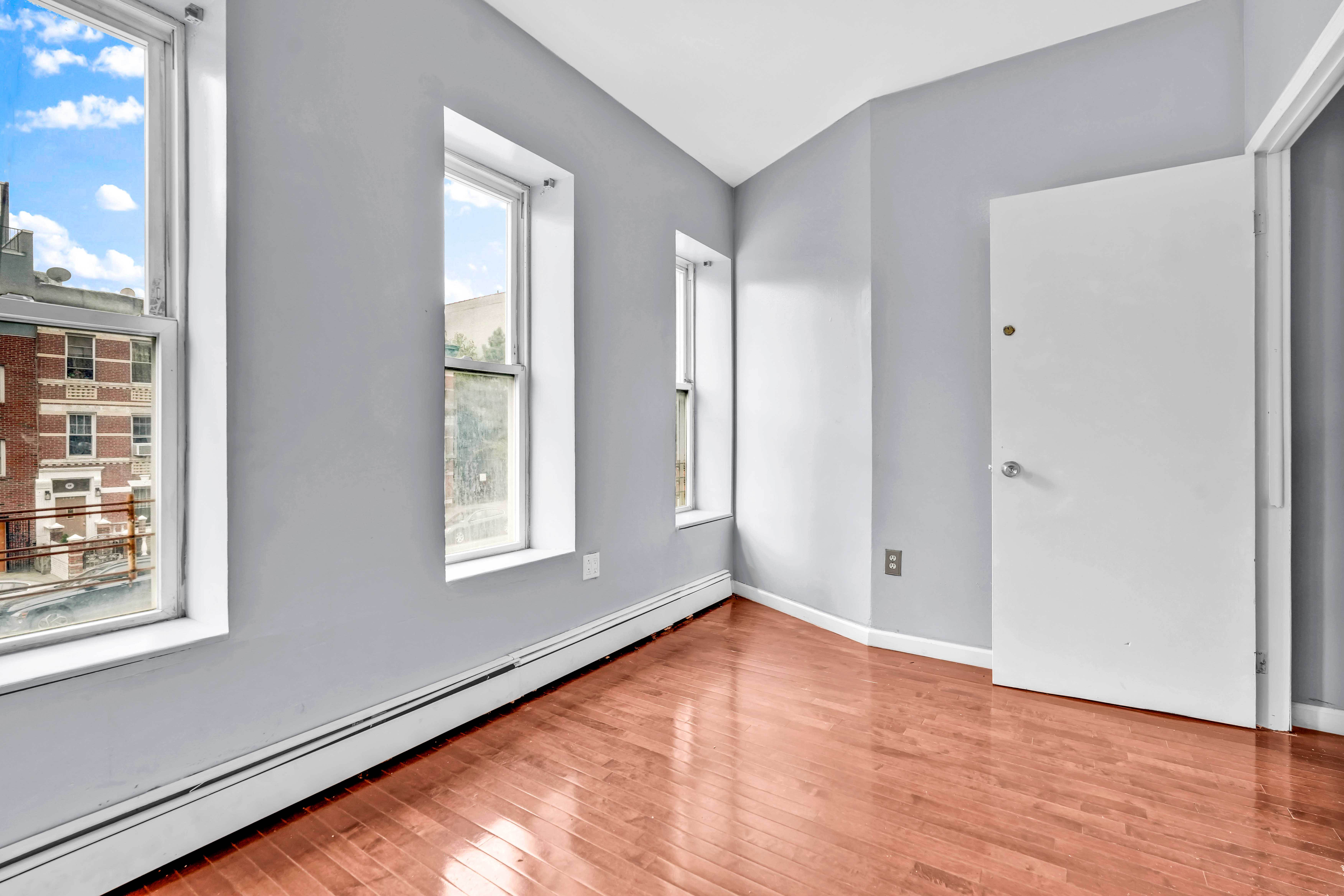 1633 St Johns Place, Unit 3 Brooklyn, NY 11233 - Photo 3 of 29 a view of an empty room with wooden floor and windows