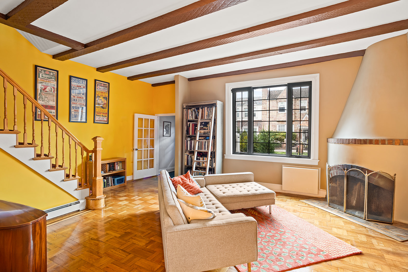 a living room with fireplace furniture and a large window
