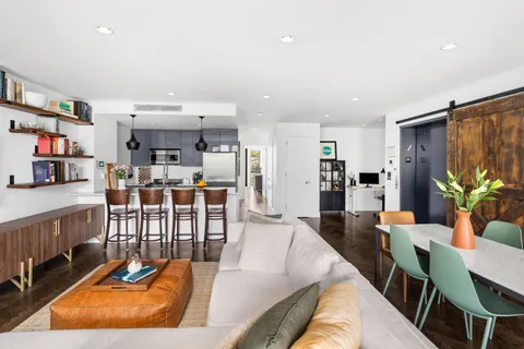 a living room with lots of furniture and kitchen view