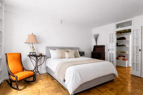 a bedroom with a bed and a chair