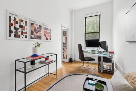 a view of a workspace with furniture and a window