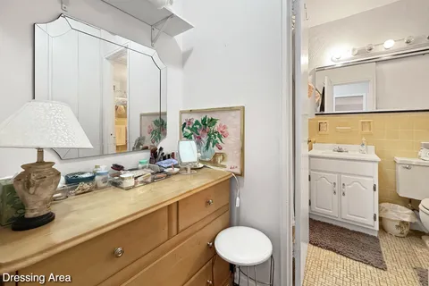 a bathroom with a granite countertop sink mirror vanity and toilet