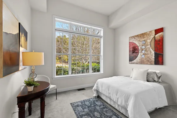 a bedroom with a bed and a painting on the wall