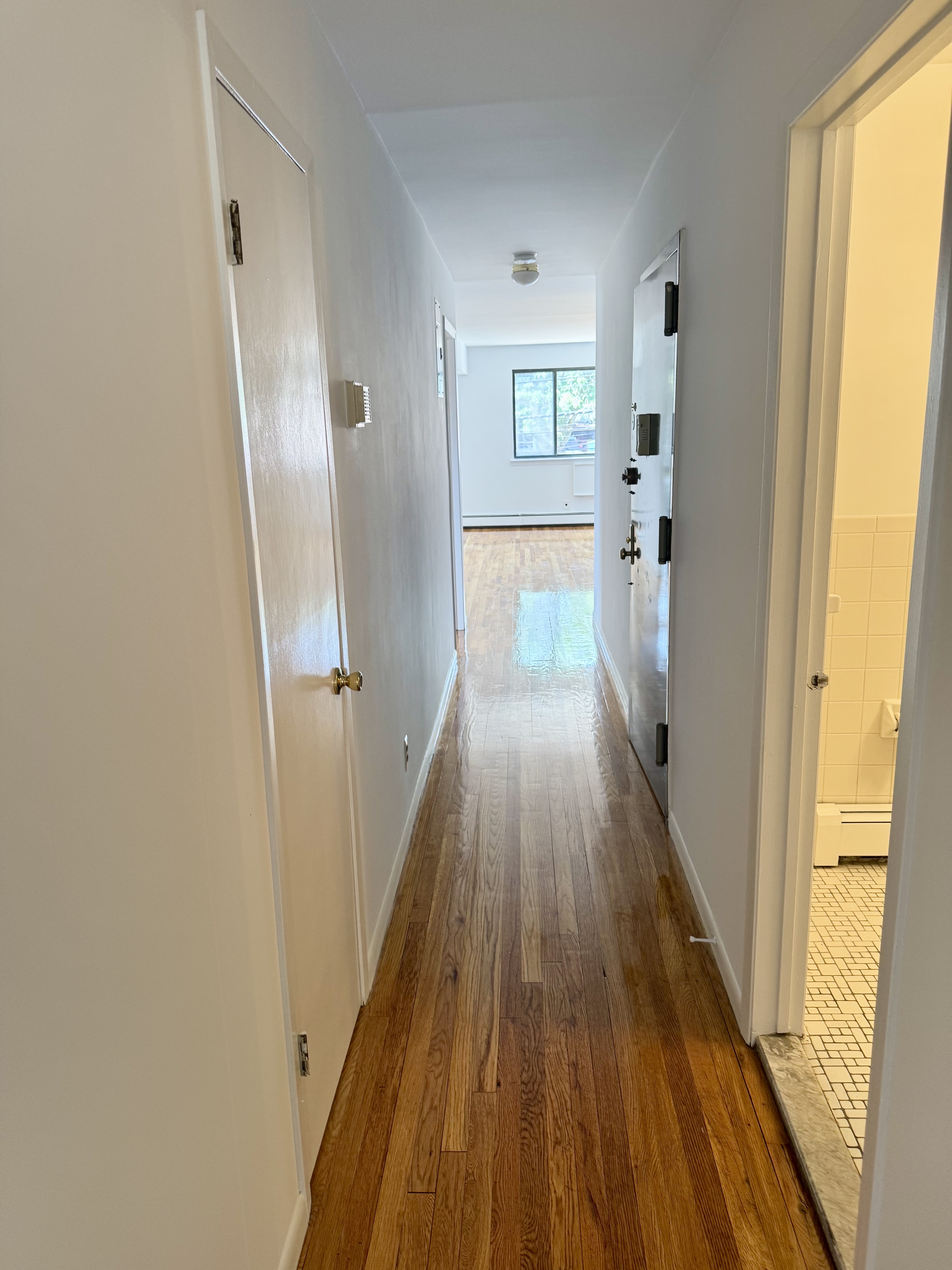 59-15 39th Avenue, Unit 2 Queens, NY 11377 - Photo 13 of 13 a view of a hallway with wooden floor and a living room