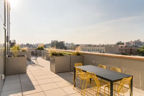 a view of a terrace with furniture and city view