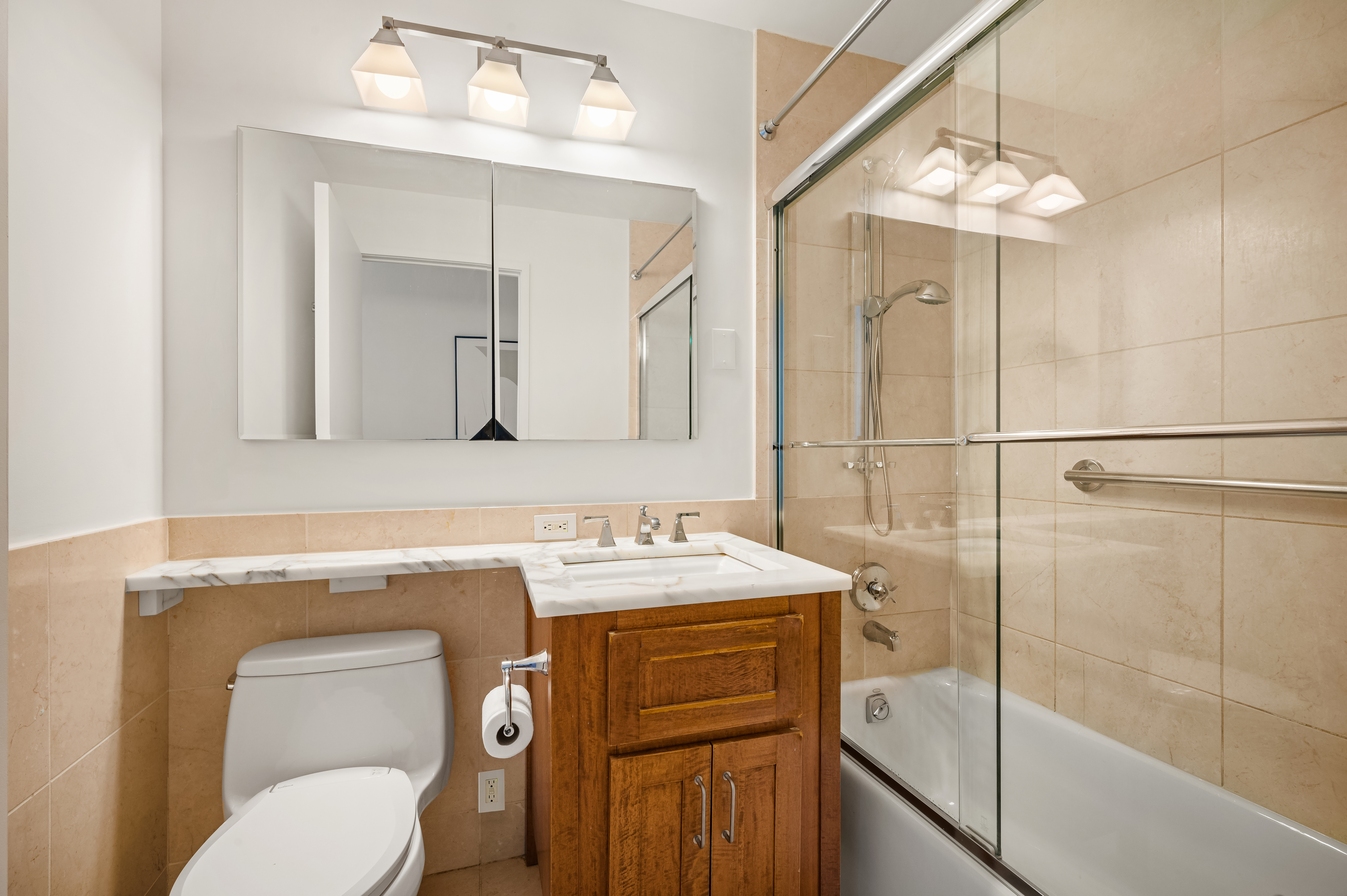 45 Park Avenue, Unit 1801 Manhattan, NY 10016 - Photo 8 of 12 a bathroom with a toilet sink vanity and mirror