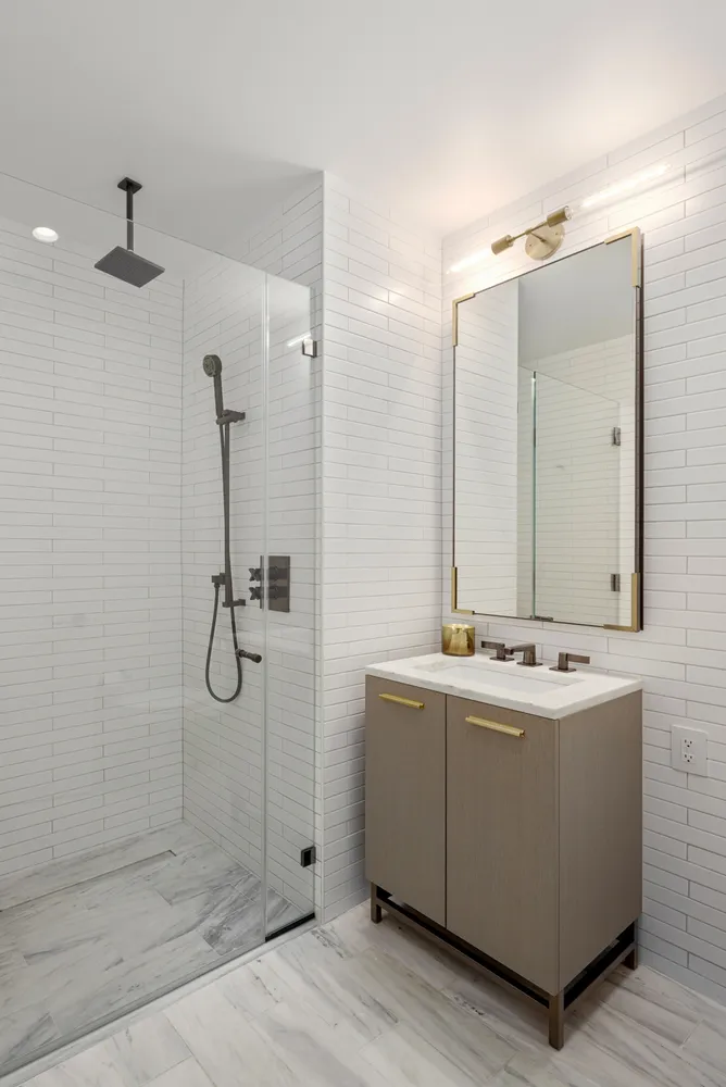 a bathroom with a double vanity sink mirror and shower