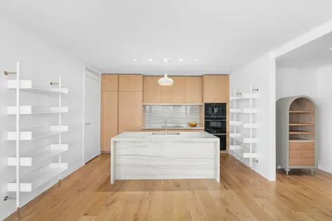 a large white kitchen with granite countertop a stove and a refrigerator