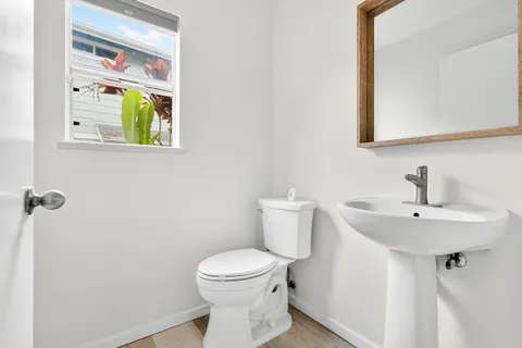 a bathroom with a toilet a sink and mirror