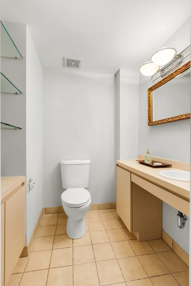 a bathroom with a sink toilet and a mirror