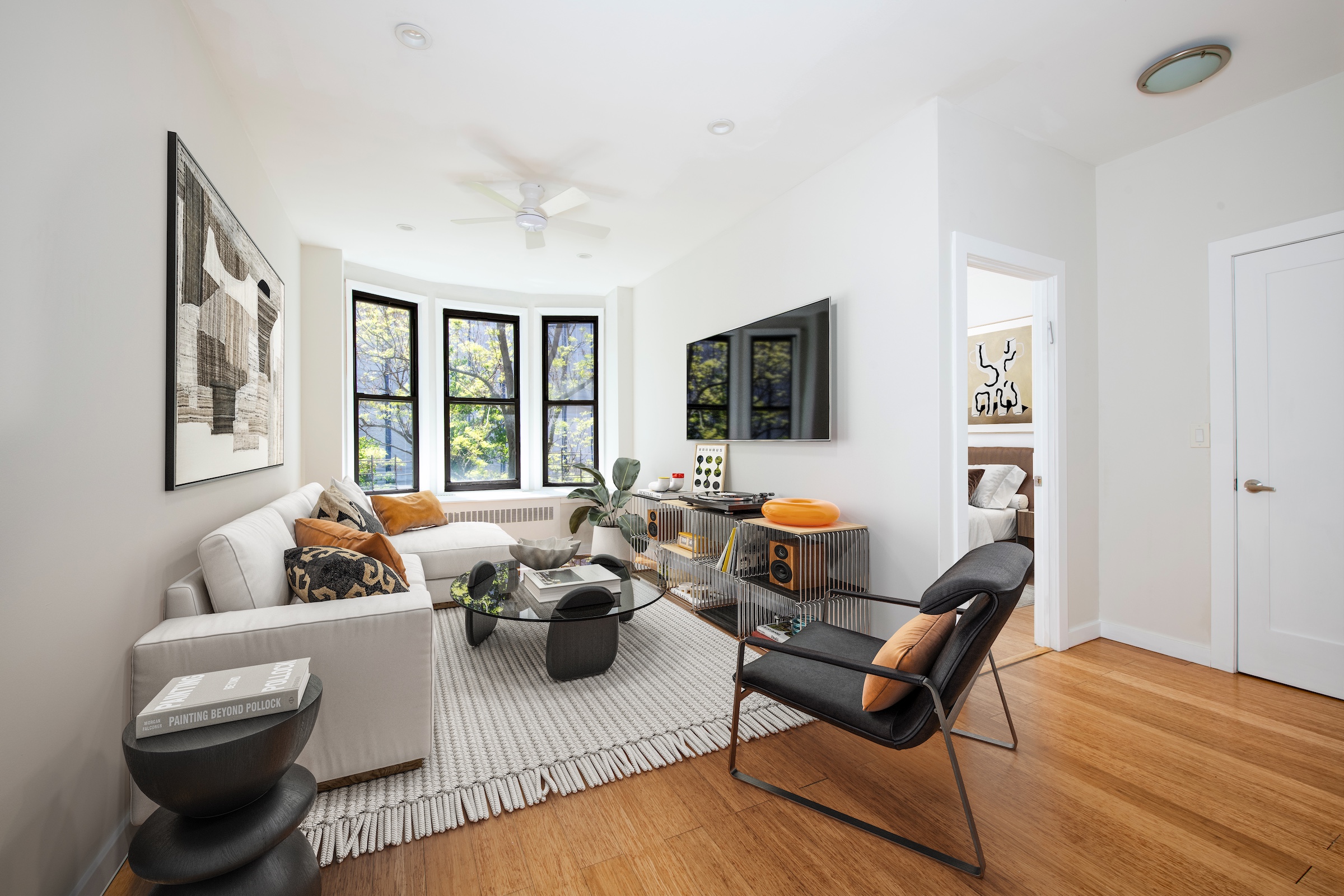 a living room with furniture floor to ceiling window and a flat screen tv
